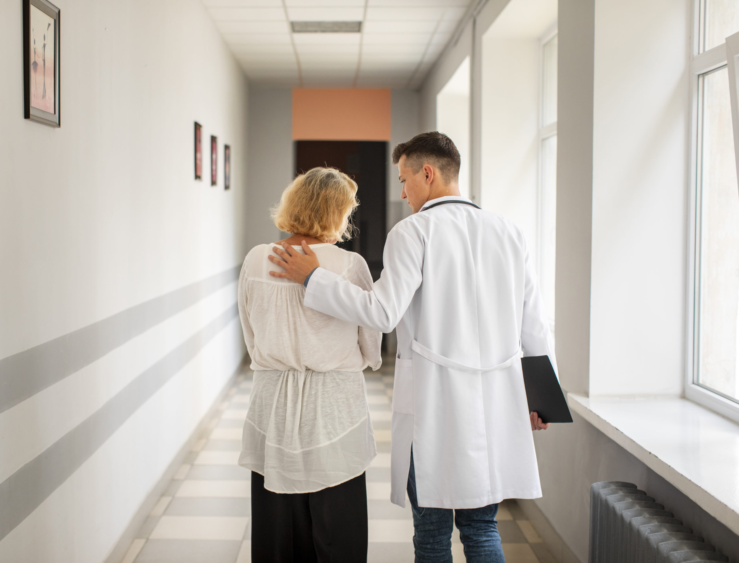 Médico acompanhando paciente no corredor